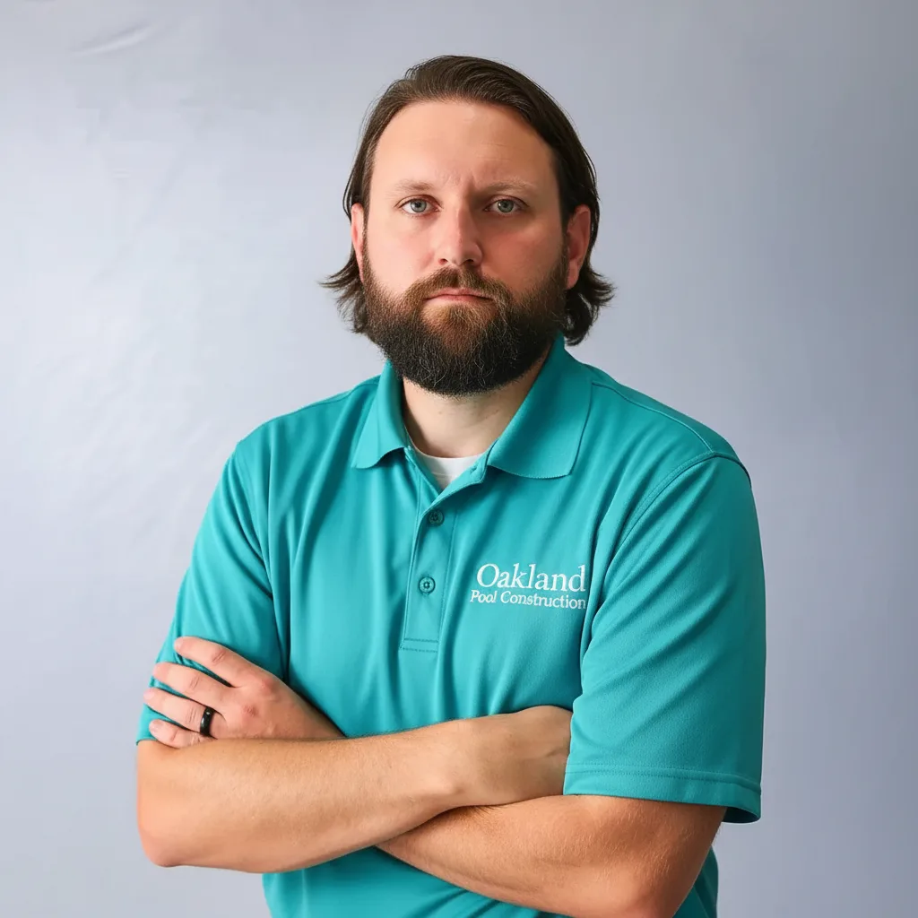 Timothy Wood, owner of Oakland Pool Construction, wearing company branded shirt with logo